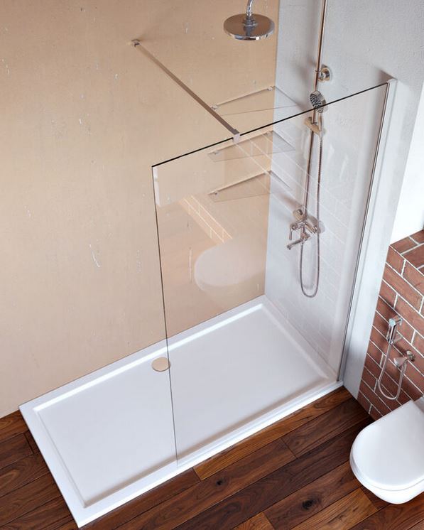 A minimalist walk in shower comprising a large shower tray and a fixed glass screen.
