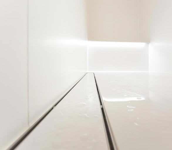 Against the wall linear drainage gully.